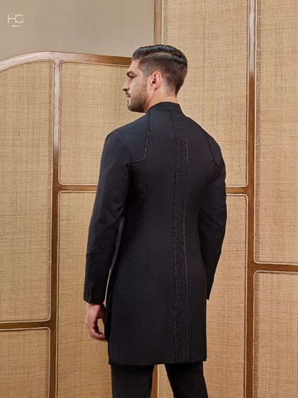 The back view of this achkan reveals subtle, shimmering detail along the spine, a hidden touch of luxury for a truly special garment.