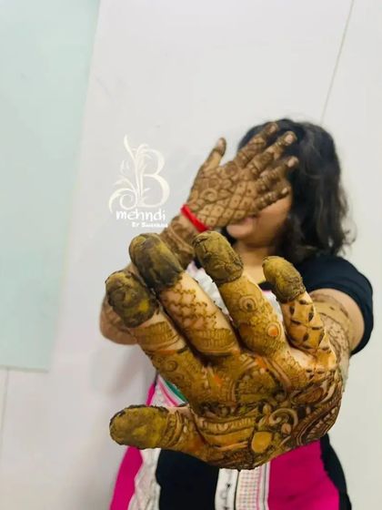 The moment of truth. A client playfully shows off her hands after the henna paste has been applied, waiting for that beautiful dark stain to appear.