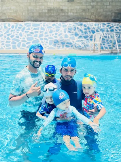 Our pool is a community. Here, a group of our young swimmers and coaches celebrate a great session together, showcasing the supportive and friendly atmosphere we foster at the academy.