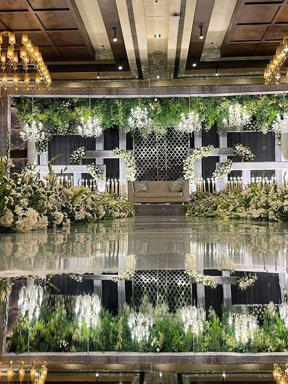 Another angle of the luxurious reception stage, showing the stunning reflection and the meticulous arrangement of flowers and lights.