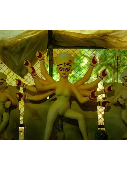 Three idols of Goddess Durga with their eyes painted, a significant ritual known as 'Chokkhu Daan', which is believed to infuse the idols with life.