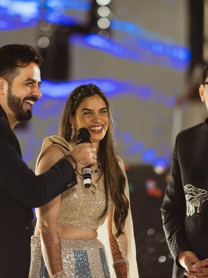 Laughter and joy as the host interacts with the bride's family on stage during the Sangeet.