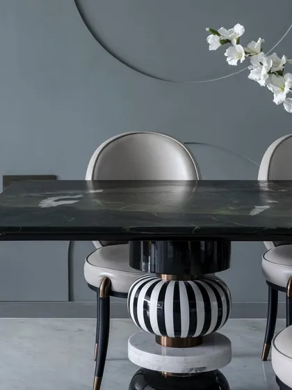 A close-up of the sculptural dining table base in 'The House of Arcs', showcasing the mix of materials and patterns.