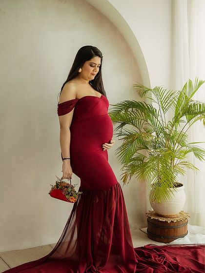 A pensive and beautiful portrait. The mom-to-be holds a small floral basket, adding a delicate, thoughtful detail to the image.