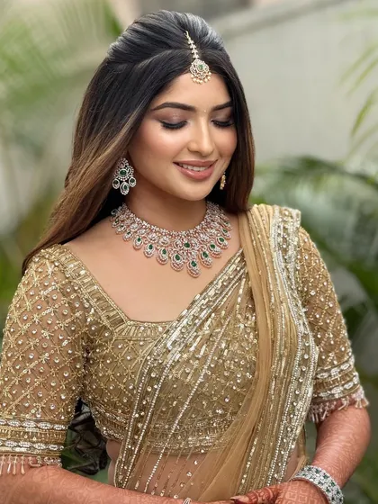 A beautiful portrait of the bride in her golden reception lehenga. The makeup is soft and radiant, enhancing her happy smile.