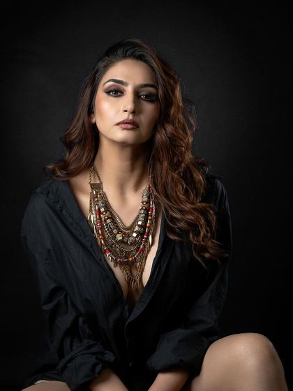 A classic portrait against a solid black background. This minimalist setup ensures all attention is on the subject, her expression, and the texture of her clothing.