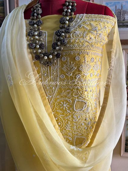 A three-quarter view of the yellow suit, styled with a necklace to demonstrate its versatility.