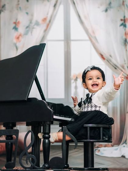 She leaves a little sparkle wherever she goes. A happy girl waves from her mini piano in our classic and elegant studio.