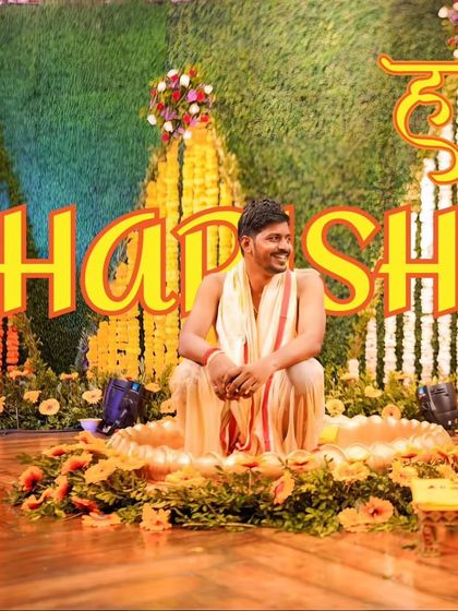 A portrait of the groom, Harsh, enjoying his Haldi ceremony, seated in a decorative setup.