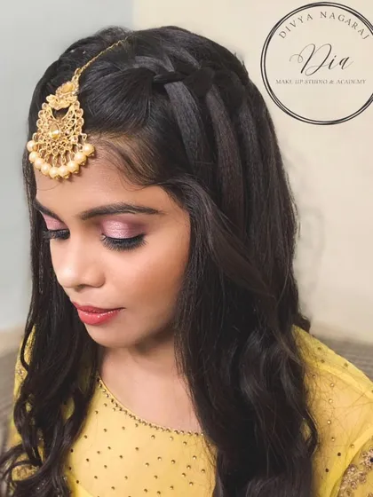 A closer look at this party makeup. The textured front braid adds a stylish element to her open hairstyle, and the pink eyeshadow is blended beautifully for a soft, glamorous effect.