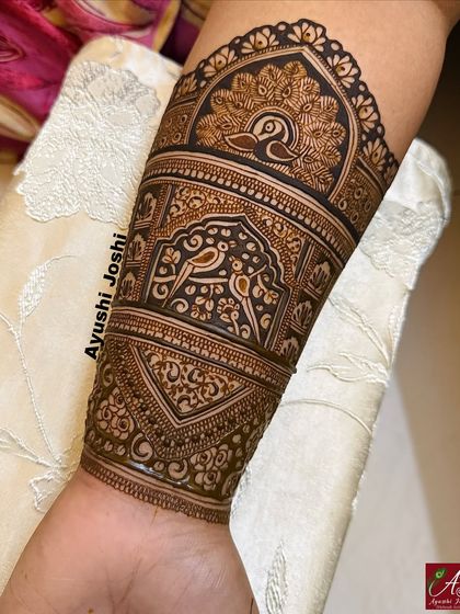 The full arm band, featuring a peacock at the top and a pair of love birds below, connected by intricate geometric patterns.