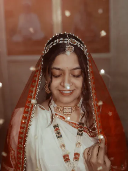 A dreamy portrait of a Bengali bride, her face gently illuminated by fairy lights, creating a soft and magical glow.
