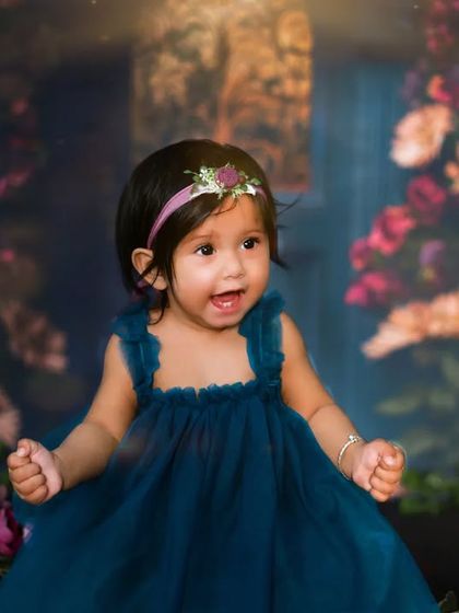 A moment of pure joy and excitement. This little girl's happy expression brings this enchanting floral-themed photoshoot to life.