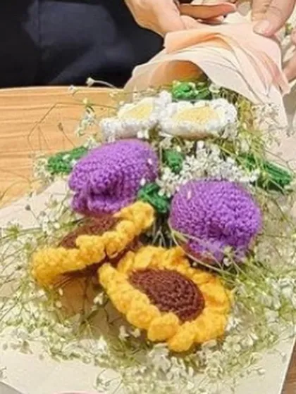 A close-up of a custom bouquet where I've blended my crochet sunflowers and daisies with delicate, real baby's breath for a soft, romantic look.