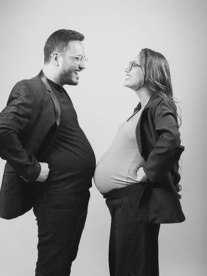 Who has the bigger bump? This playful black and white shot is full of humor and personality. It shows a couple who doesn't take themselves too seriously and is ready to embrace the fun of parenthood.