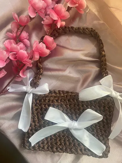 My handmade ribbon bag, styled with some pink flowers. You can choose the yarn color and the ribbon color for a fully custom piece.