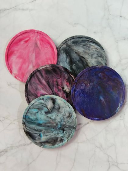 A collection of our coasters, showcasing the variety of colors and patterns available. Each one tells a different story of recycled materials.