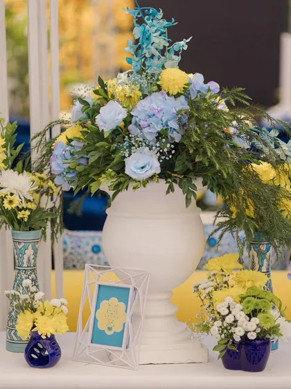 A beautiful floral centerpiece in shades of blue and yellow, perfectly matching the fresh and modern theme of the Haldi.