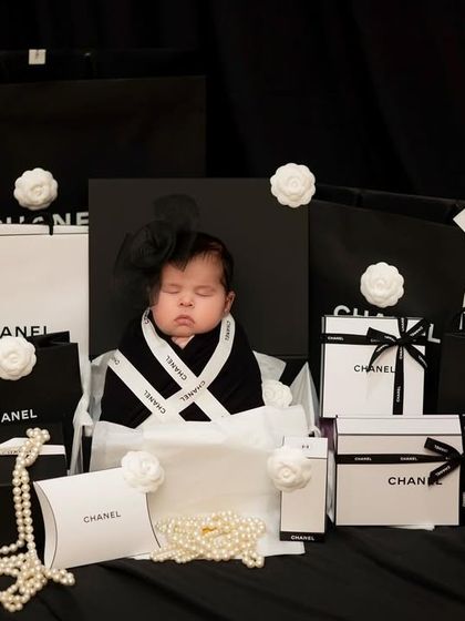 A different angle of our little fashionista, nestled among iconic black and white gift boxes and pearls.