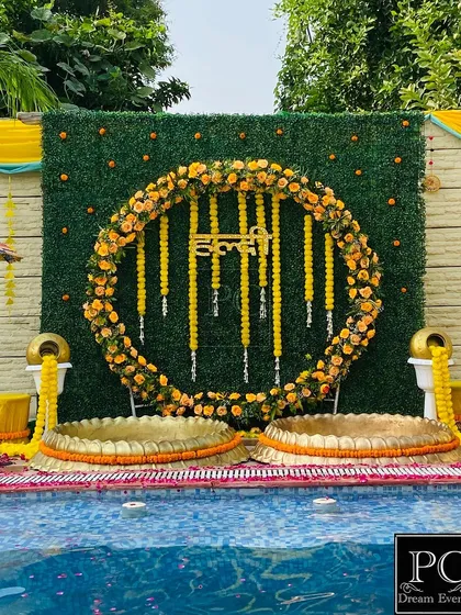 I love creating stunning poolside Haldi setups. For this event, I designed a circular marigold floral backdrop against a lush green wall, complete with traditional brass urlis, making it a perfect blend of modern and classic Haldi decor.