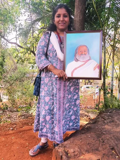 Here I am in the serene environment of the Art of Living ashram in Bangalore, holding my completed oil portrait of Sri Sri Ravi Shankar.