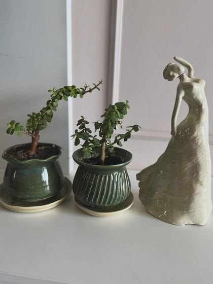 Another view of the dancing woman sculpture alongside the green planters. They make a lovely little family of handmade objects.