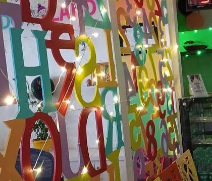 I love adding creative touches to our decor. This colorful wall of letters, intertwined with fairy lights, adds a playful and educational element to our cafe area.