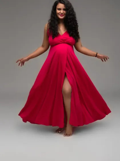 Unleash your inner queen with a bold and dynamic pose. This vibrant red flowing gown is part of my extensive collection, perfect for creating powerful and fashionable maternity portraits.