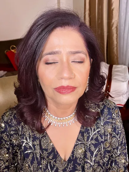 A close-up of the makeup for the mother of the groom. The look is sophisticated, with soft smokey eyes and a classic red lip.