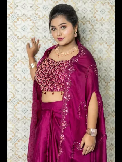 A close-up of the magenta Indowestern outfit, showing the intricate pattern on the blouse and the delicate embroidery on the cape.