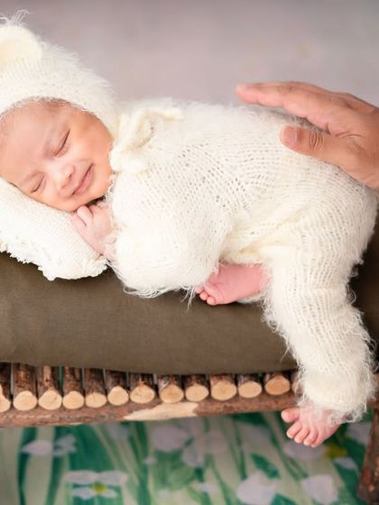 This little teddy bear is all smiles. Capturing a newborn's smile, even in their sleep, is a magical moment.