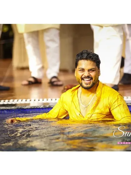 A happy groom, drenched but smiling. This shot after being thrown in the pool perfectly captures the fun-loving spirit of the Haldi celebration.