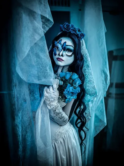 A hauntingly beautiful look inspired by the Corpse Bride. The blue-toned skin, large expressive eyes, and tattered veil perfectly capture the character's melancholic beauty.