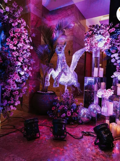 A close-up of the decor details, including a sparkling pegasus statue, mirrored pedestals, and lush purple floral arrangements that enhanced the celestial theme.