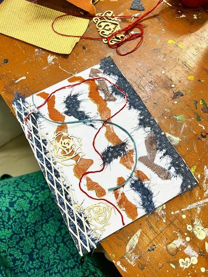 A collagraph plate being prepared. This technique involves creating a collage of different materials on a plate to create unique textures in the print.