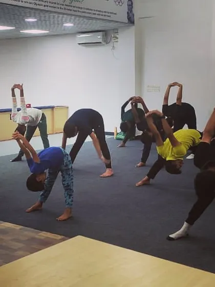 Yoga poses like the forward bend help release tension in the back and shoulders, areas that bear a lot of stress during shooting practice.