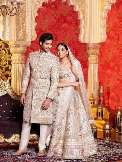 This shot is from an ethnic wear campaign, showcasing a coordinated couple's look for the wedding season. The intricate ivory sherwani and lehenga were styled to create an image of regal elegance and romance.