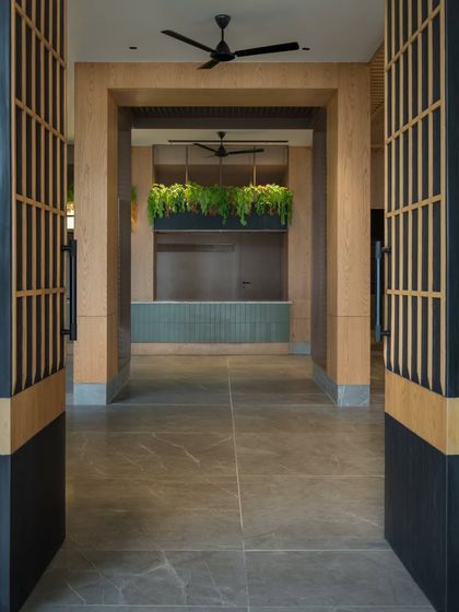 The grand entrance to the auditorium lobby. The symmetrical design, natural materials, and hanging greenery create a welcoming and impressive entryway for students and visitors.