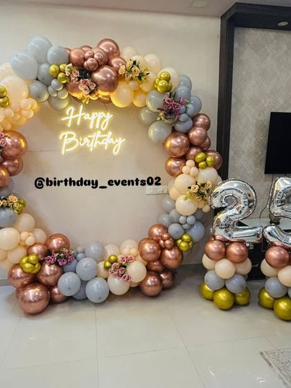 A wide shot of the 25th birthday decor, showing how the ring backdrop and number balloons create a complete and impressive photo zone in a living room.