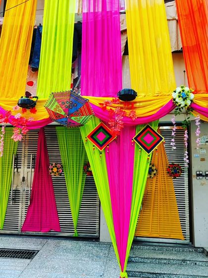A close-up of a gate decorated with neon-coloured drapes, showing how I can create a modern and vibrant entrance.