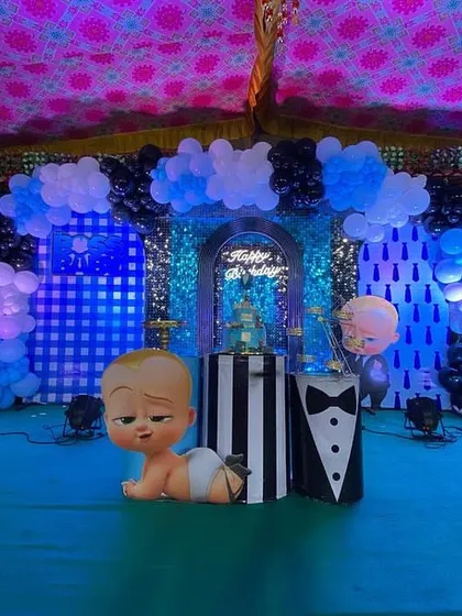 A centered shot of the Boss Baby stage, featuring a crawling Boss Baby prop in the foreground and a cake stand ready for the main event.
