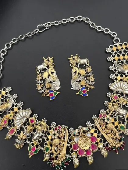 A whimsical and intricate fusion necklace set. This piece combines silver and gold-plated elements with colourful enamel work, featuring a variety of animal and floral motifs for a truly one-of-a-kind design.