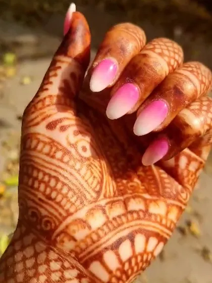A beautiful pink and white ombré manicure, shown here complementing an intricate henna design.
