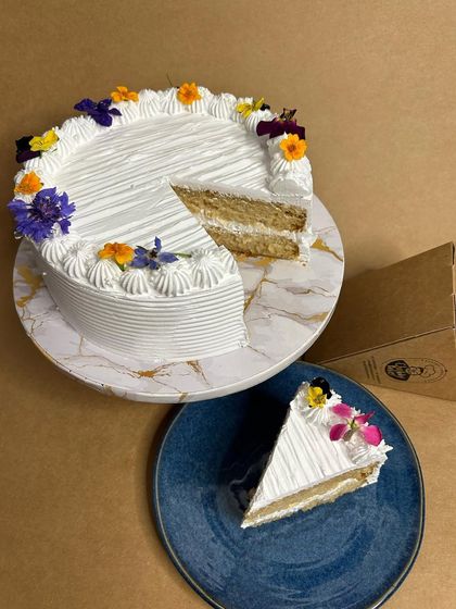 My version of the classic Mexican dessert, Dulce de Tres Leches. This light and airy sponge cake is soaked in three kinds of milk and topped with whipped cream and edible flowers. Also available by the slice!