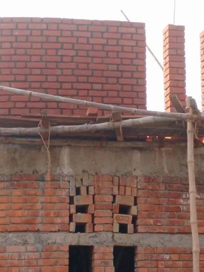 The upper level of the Ashadeep School features a rhythmic pattern of brick piers. This detail adds a layer of texture and complexity to the facade while maintaining the honest, robust character of the locally sourced brick.