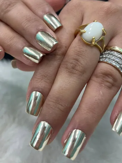 Make a bold statement with these full-coverage liquid gold chrome nails. This reflective, mirror-like finish is applied over perfectly shaped square extensions for a look that is pure luxury and guaranteed to turn heads.