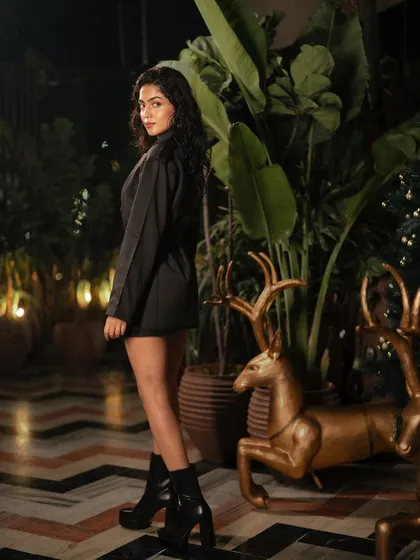 A night-time fashion shoot for Freyja in a beautifully decorated location. The warm ambient lights and lush plants create a magical, enchanting atmosphere.