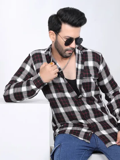 A stylish studio shot for a men's fashion brand, showcasing a casual yet sharp look with a plaid shirt, highlighting our versatility in men's apparel photography.