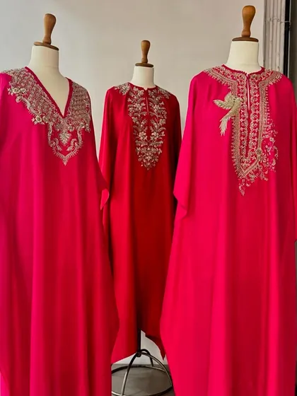 A trio of elegant red and pink kaftans, each with unique gold and silver embroidery, perfect for any festive party.