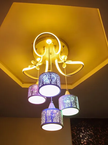 A whimsical and decorative ceiling light fixture with intricate, laser-cut shades that cast beautiful patterns.